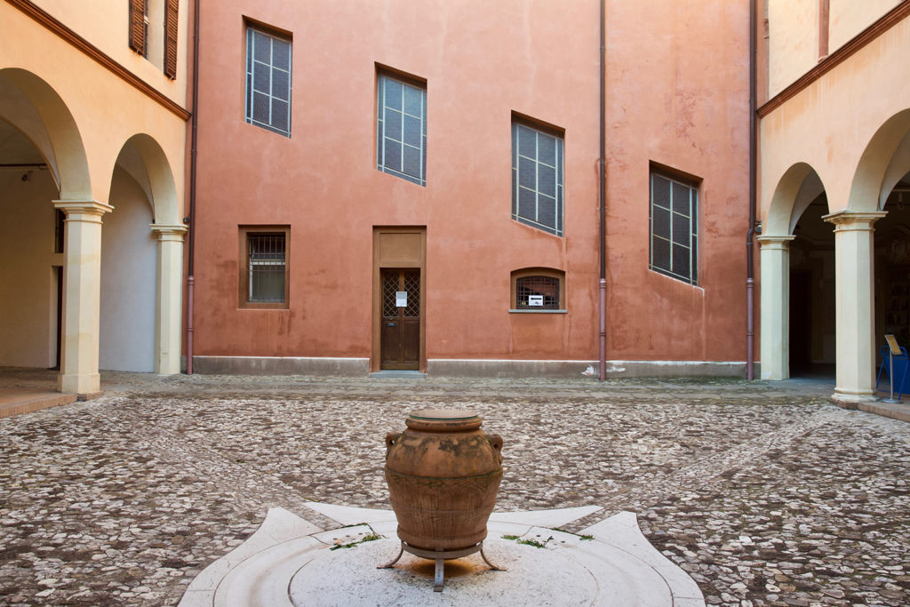 Cortile del palazzo Arcivescovile di Imola. Si vede un cortile in selciato, e la facciata del palazzo.