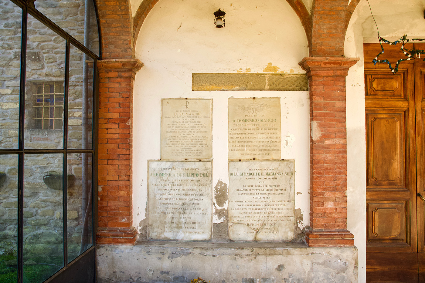 Lapidi di Sant'Apollinare, una delle chiese Casola. Si vedono quattro lapidi su un muro, attorniati da due bassi pilastri in muratura.