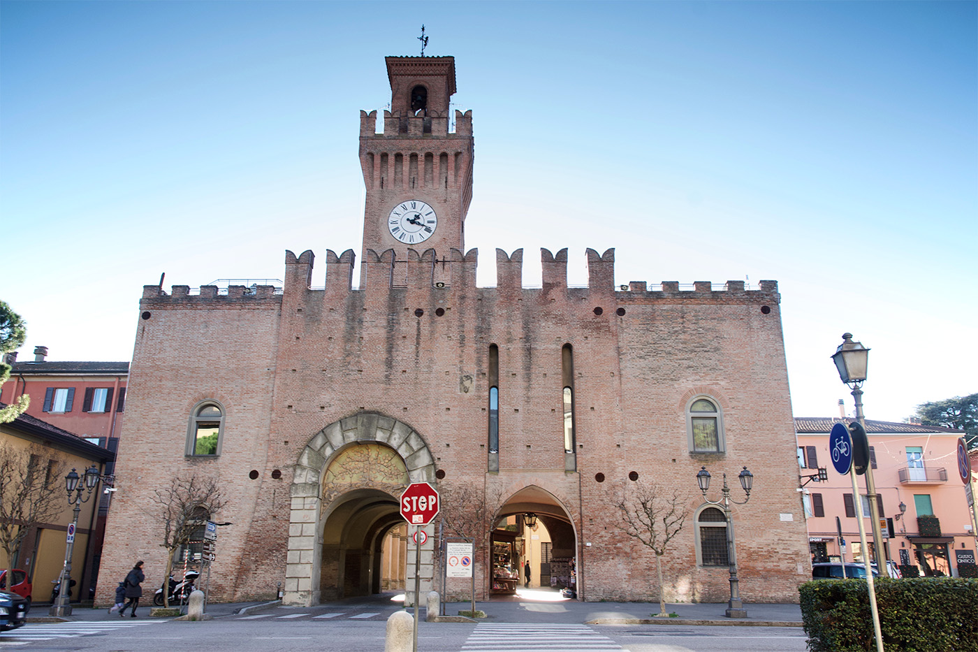 Rocca di Castel San Pietro, nella Romagna imolese. Si vede un castello con merlatura a coda di rondine, portone con arco in marmo, e un'alta torre con orologio.