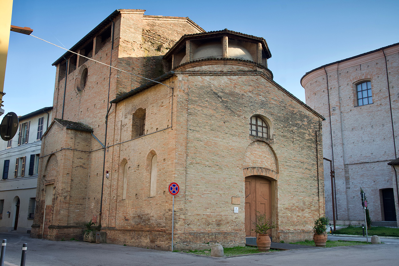Oratorio di San Sebastiano. Si vede un edificio rinascimentale forlivese, a pianta centrale, con una porta d'accesso e timpano ottagonale.